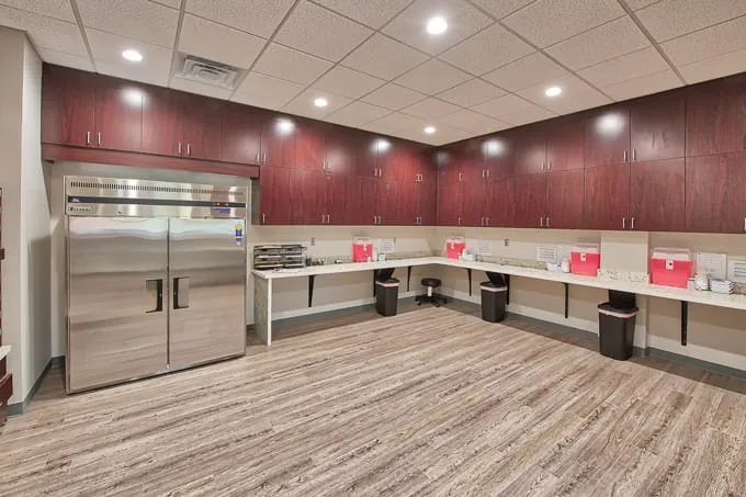 Allergy lab with a stainless steel refrigerator, wood cabinets and prep counters at Allergy & Asthma Physicians of Commerce Township