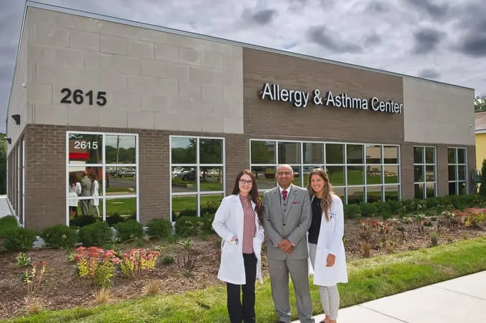 Dr. Pulin Patel and two team members outside the entrance of Allergy & Asthma Physicians of Commerce Township in Commerce Township