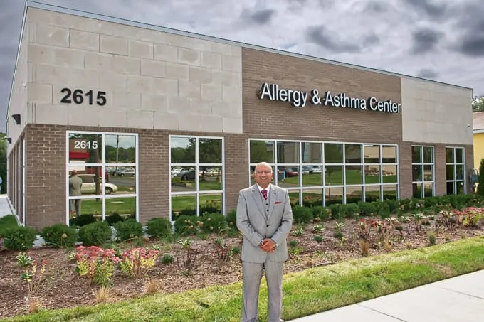 Dr. Pulin Patel standing outside the entrance of Allergy & Asthma Physicians of Commerce Township in Commerce Township