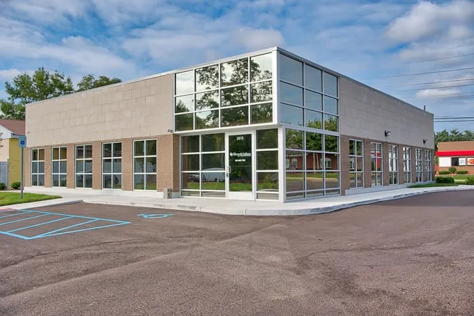Glass corner entrance and parking lot at Allergy & Asthma Physicians of Commerce Township in Commerce Township