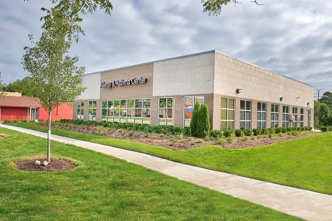 Building sign, front walkway and young tree at Allergy & Asthma Physicians of Commerce Township in Commerce Township